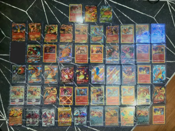 Dozens of Charizard cards in top-loaders spanning many sets